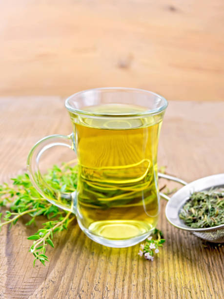 istock Tea of thyme in mug with strainer on board 1258506248