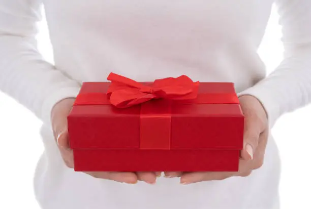 woman holding a gift box in a gesture of giving isolated on white background