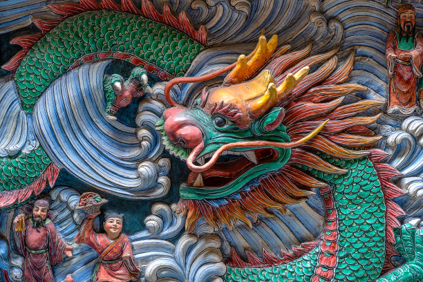 detail of a dragon statue on a wall in a chinese temple in singapore, closeup - dragon china singapore temple imagens e fotografias de stock