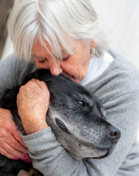 istock Elderly woman hugs her very old dog. 1258520414