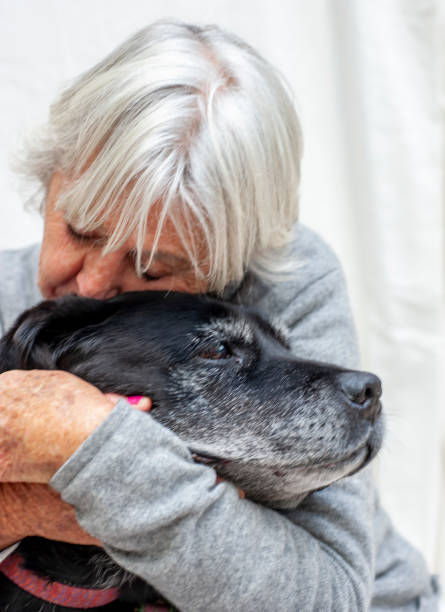 istock Elderly woman hugs her very old dog. 1258522009