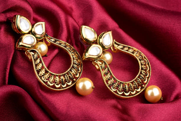 美しい黄金のイヤリングのペア は赤サズの背景にダイヤモンドの宝石。高級女性ジュエリー、インドの伝統的なジュエリー、クンダンイヤリング、ブライダルゴールドイヤリングウェディン - antique traditional culture earring pair ストックフォトと画像