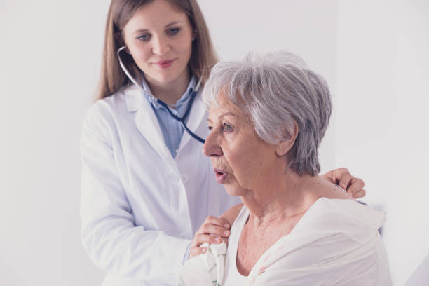 médico femenino que escucha los pulmones de los pacientes - bed hospital prognosis patient fotografías e imágenes de stock