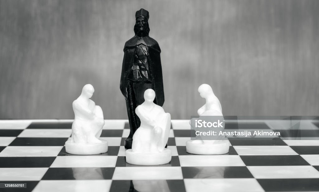 Black and white chess pieces on the chessboard. The concept of combating racism. Motivational poster against racism and discrimination Black and white chess pieces on the chessboard. The concept of combating racism. Motivational poster against racism and discrimination. Anti-racism Stock Photo