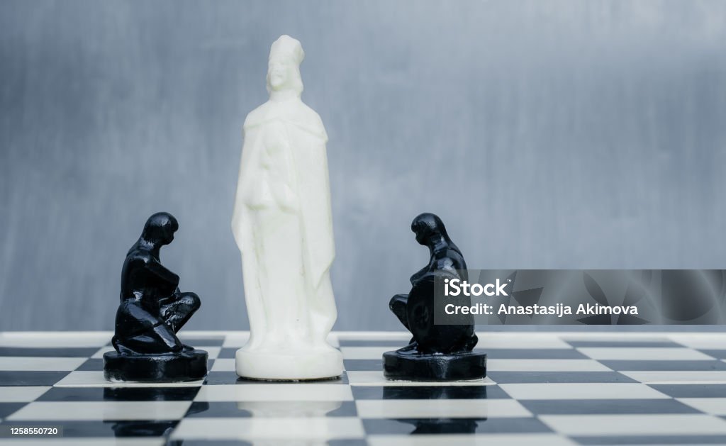 Black and white chess pieces on the chessboard. The concept of combating racism. Motivational poster against racism and discrimination Black and white chess pieces on the chessboard. The concept of combating racism. Motivational poster against racism and discrimination. Activity Stock Photo