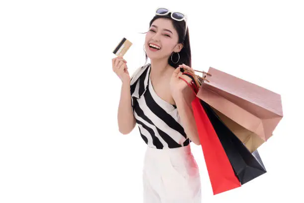 happy woman holding credit card and shopping bag isolated on a white background