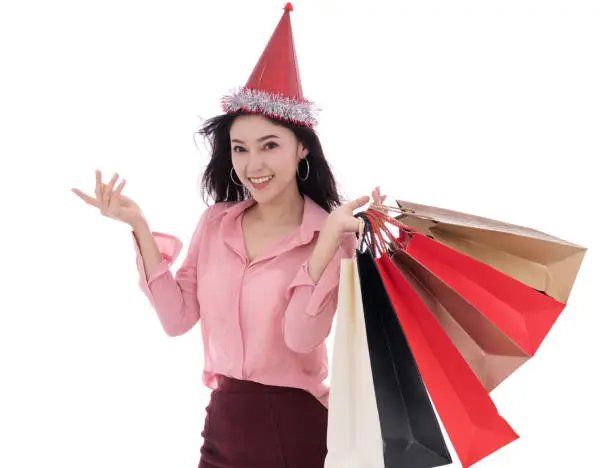 happy young woman with hat and holding a shopping bag isolated on a white background