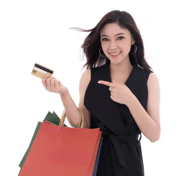 happy woman holding credit card and shopping bag isolated on a white background