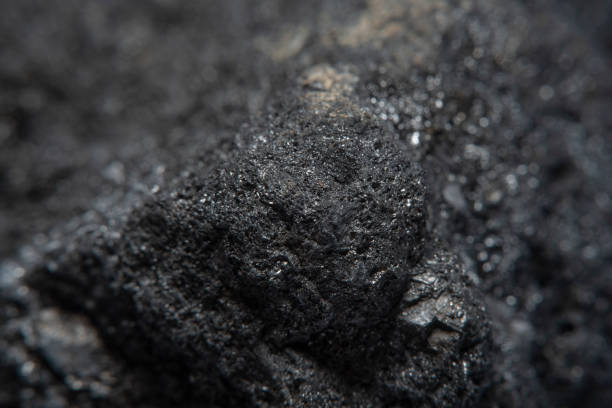 istock Blurred black background in soft focus with hard coal at high magnification. An image on the theme of geology and the extraction of minerals and natural fuels. 1258642801