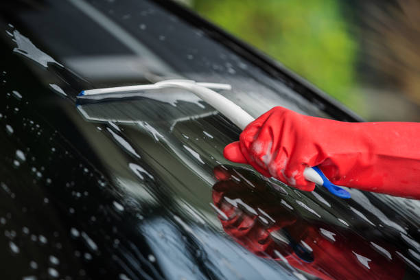 istock hand using squeegee to washing windshield of car 1258654006