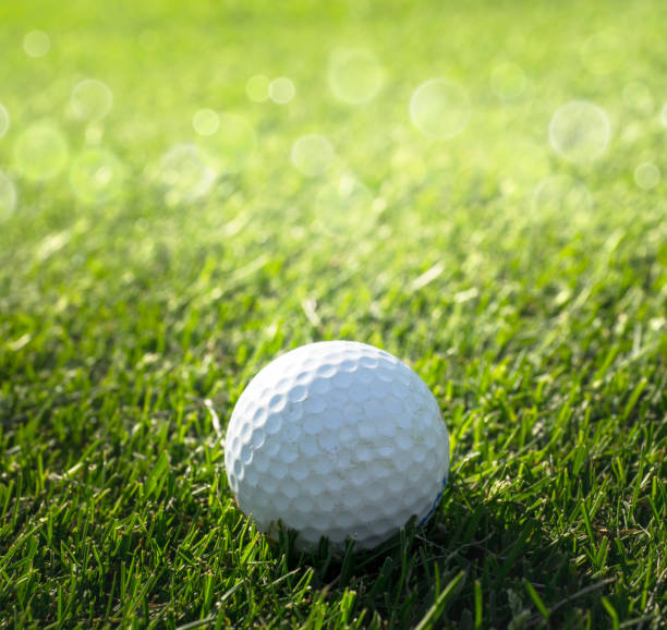 istock Golf course with a golf ball on a putting green and bokeh effect. 1258680221