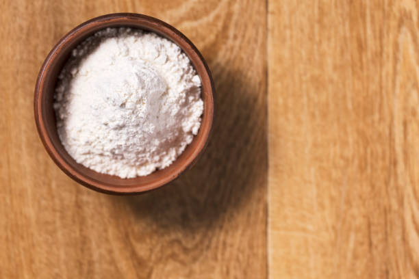 istock Bread flour in a bowl on a wooden table top view. 1258681360
