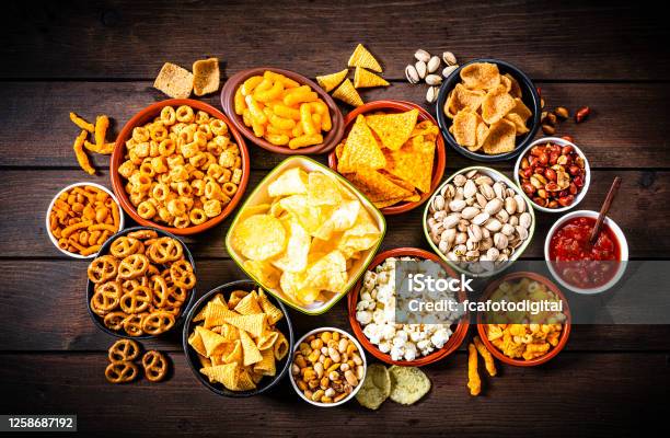 Salty Snacks Assortment Shot From Above On Rustic Wooden Table Stock Photo - Download Image Now