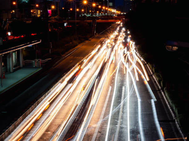istock Long exposure light trails on the street at night, motion speed traffic light with blurred traces from cars on road 1258689255