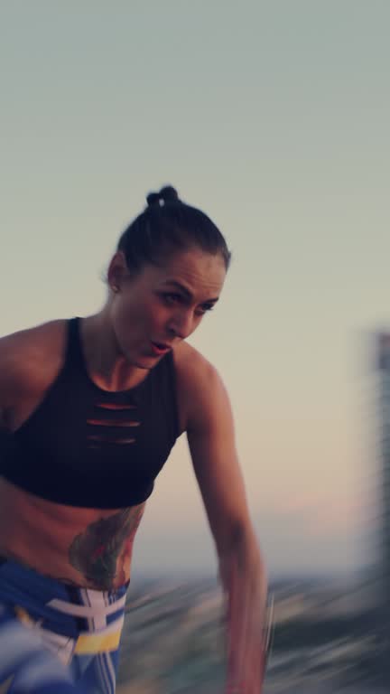Woman in sport clothing enjoying sunset city panorama. Running and jumping.