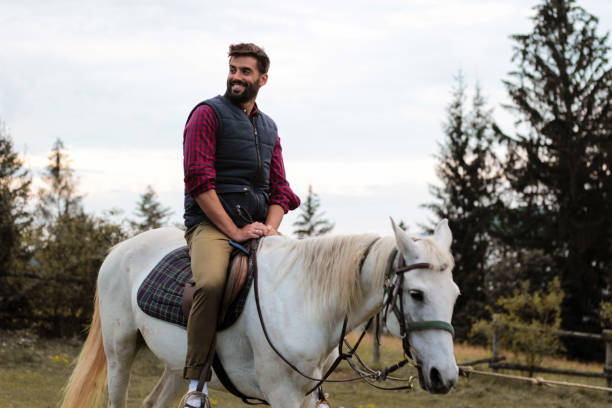 istock a handsome man rides a beautiful white horse in a mountain forest 1258733951