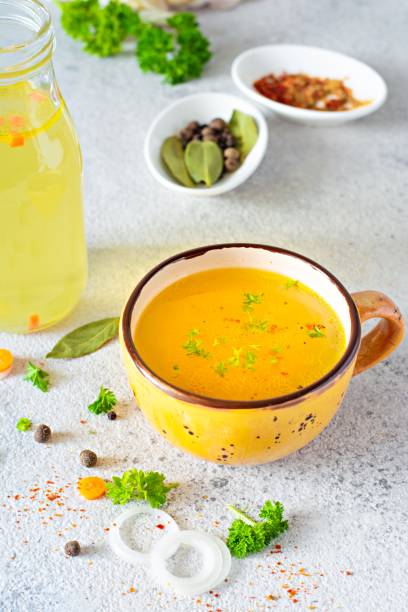 istock Homemade chicken (bone) broth/bouillon with vegetables, spices and herbs in a bowl (cup) on a light background. Natural collagen of animal origin. Liquid broth from meat, fish, vegetables. 1258746241