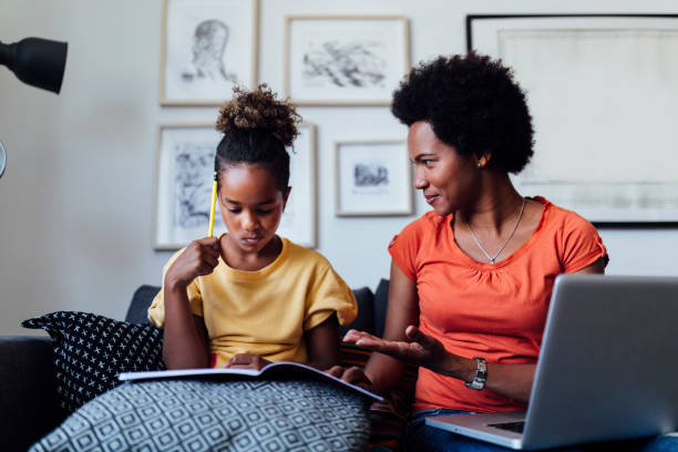 feliz madre afroamericana en casa de la escuela de su hija pequeña - concentration teacher business copy space fotografías e imágenes de stock