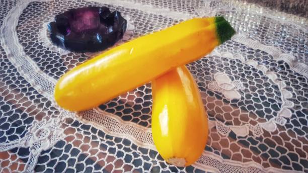 due zucchine gialle e posacenere su un doily - doily freshness raw sweet food foto e immagini stock