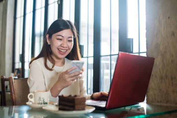 istock Asian woman working on laptop computer in cafe 1258789388