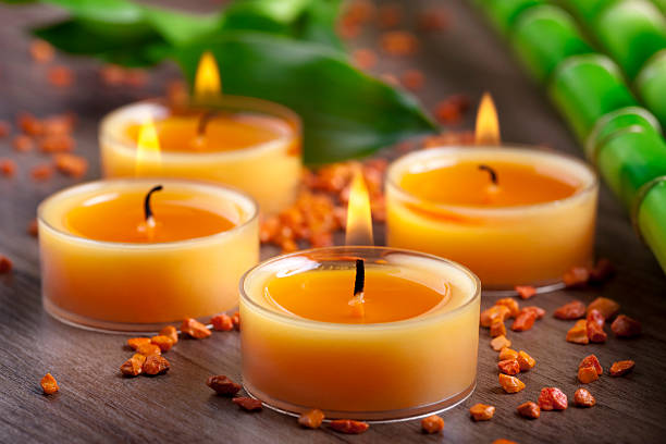 небольшие оранжевый свечи и камни с бамбуковых украшения - spa treatment health spa zen like bamboo стоковые фото и изображения