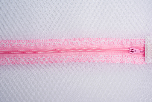 pink plastic zipper on the laundry bag, full frame, close up