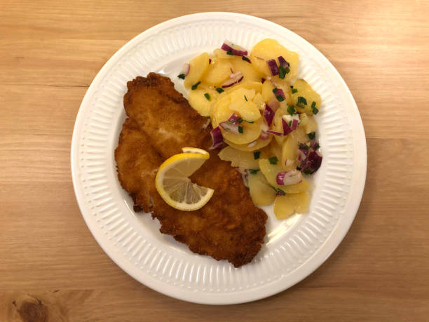 breaded, baked fish plaice fillet with potato salad and red onions.t - floe lake imagens e fotografias de stock