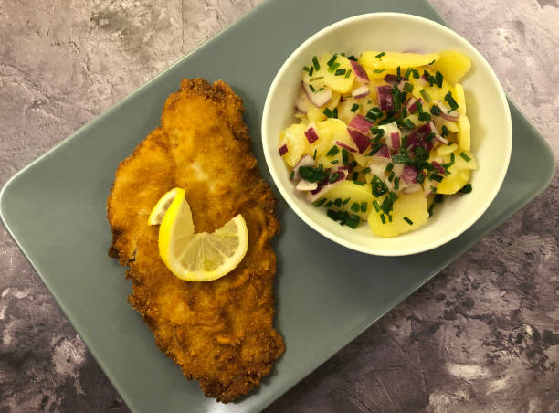 filetto di passera di mare di pesce impanato al forno con insalata di patate e cipolle rosse.t - floe lake foto e immagini stock