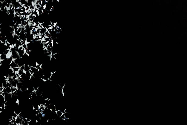 istock Silver stars confetti on a black background. Dark festive backdrop. 1258825240