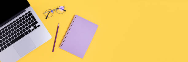 istock Banner with laptop, glasses and notepad on a yellow background. 1258829490