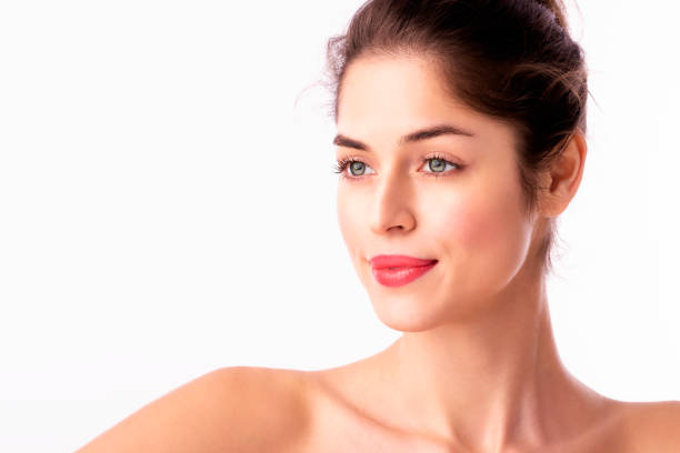 istock Beautiful woman wearing red lipstick while standing at isolated white background 1258838926