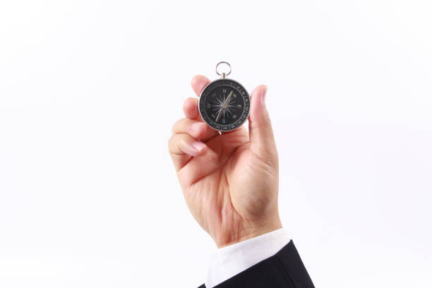 istock Business man hand holding compass, isolated on white background 1258863021