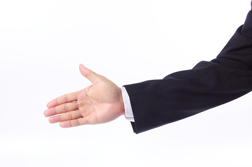 Hand of businessman in suit showing gun sign, isolated on white background