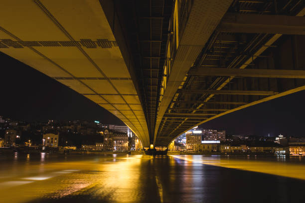 Beautiful Branko's bridge at night with night lighting, under the bridge, Sava river and town in distance, Belgrade, Serbia.