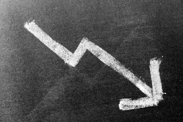 istock White chalk hand drawing in arrow down shape on black board background (Concept of stock decline, down trend of business, economy) 1258873074