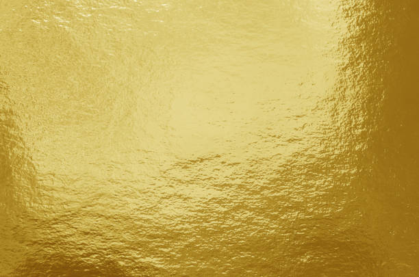 istock Gold foil background with highlights and uneven texture 1258875728