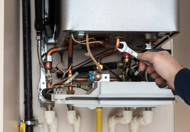 istock Technician is holding wrench in front of combi gas boiler 1258888445