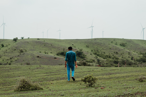Portrait of an Indian man standing in front of green hills