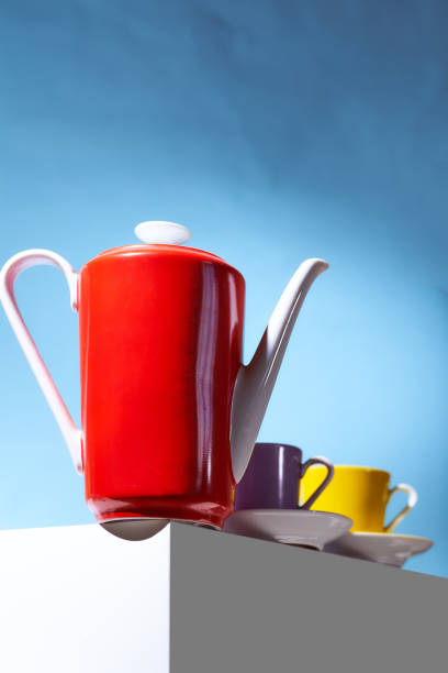 istock Red coffee teapot and two cup for coffee shop stand on a white cube 1258908250