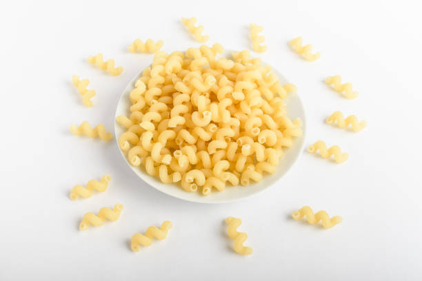 istock Dried serpentelli Italian pasta in a round bowl ready to be cooked, isolated on a white table, top view or flat lay of healthy food 1258912228
