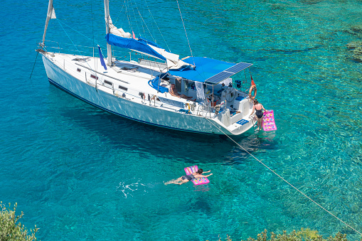 Recreational sailing boat moored on a beautiful turquoise sea of aegean. Fun and relaxing in sail vacation.