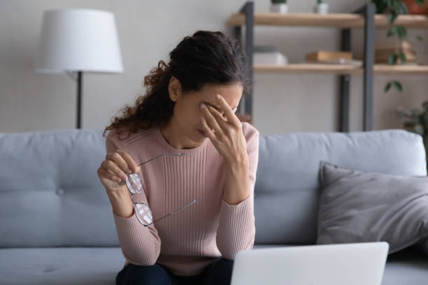 istock Tired young woman rub eyes suffering from migraine 1258916200