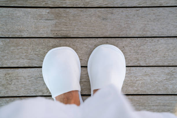 donna che soggiorna in pantofole bianche su pavimento in legno nella terrazza dell'hotel. vista dall'alto - shoe groom wood luxury foto e immagini stock