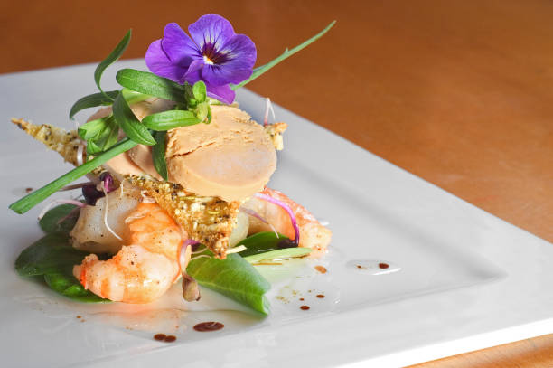 istock Cold dish with edible flower, scampi and fish paste on white plate 1258954425