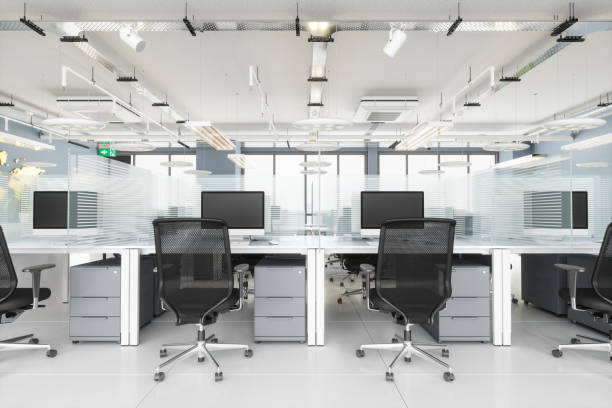 istock Social Distancing in Modern Office. Office Desk With Glass Partition Dividing Them 1258990664