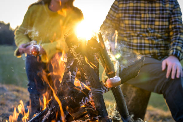 istock Man and woman baking sausages at a campfire 1259000747