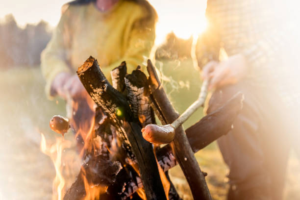 istock Man and woman baking sausages at a campfire 1259000787