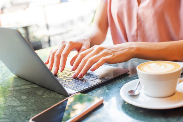 istock Unrecognizable businesswoman using laptop while working from cafe 1259003026