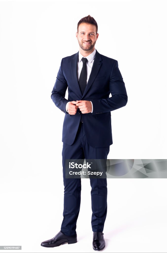 Studio shot of handsome businessman wearing suit while standing at isolated white background Full length shot of handsome businessman wearing suit while standing at isolated white background. Suit Stock Photo