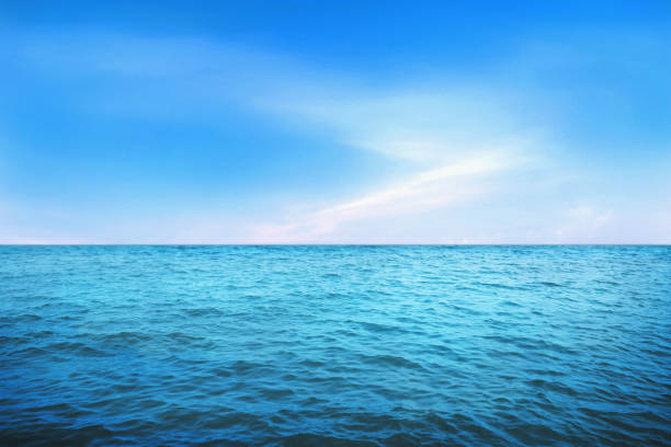 istock BLUE UNDER WATER waves and bubbles. Beautiful white clouds on blue sky over calm sea with sunlight reflection, 1259036960